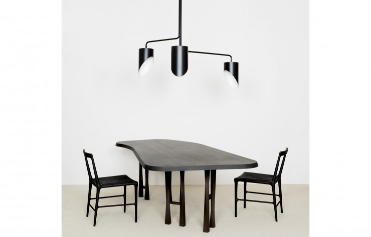 Entre matière brute et lignes élégantes, la table de repas « TWI », accompagnée de deux chaises « OUD » et ornée d’une suspension « SWN », celle-ci dessinée par Forest & Giaconia.