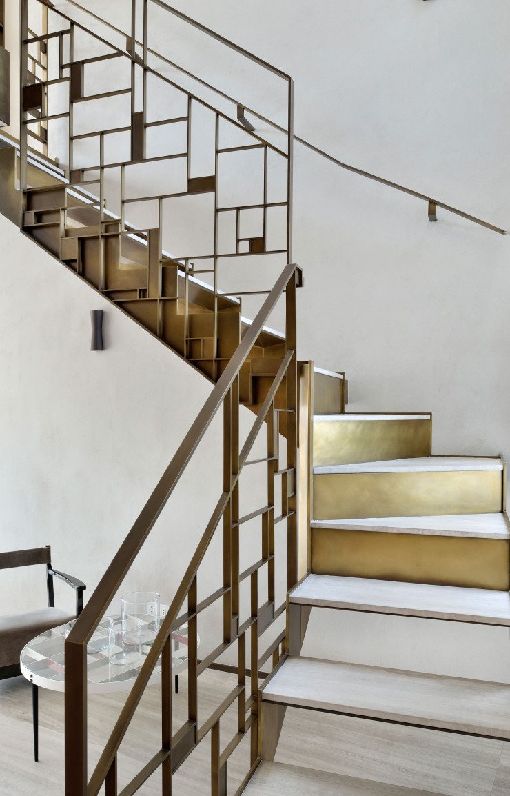 Les deux niveaux de l’appartement sont reliés par un escalier sculptural en laiton brossé et ciré conçu par 8&A.