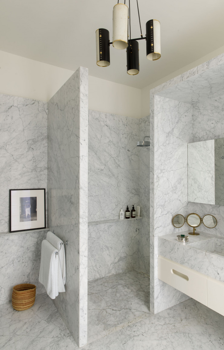 Dotée de lignes sobres, la salle de bains de maître est habillée de marbre de Carrare.
