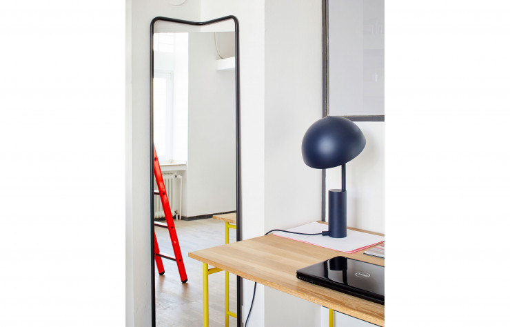 Sur le bureau, une version bleue de la lampe Cap. Dans l’angle, le Floor Mirror (2013), édité par Menu.