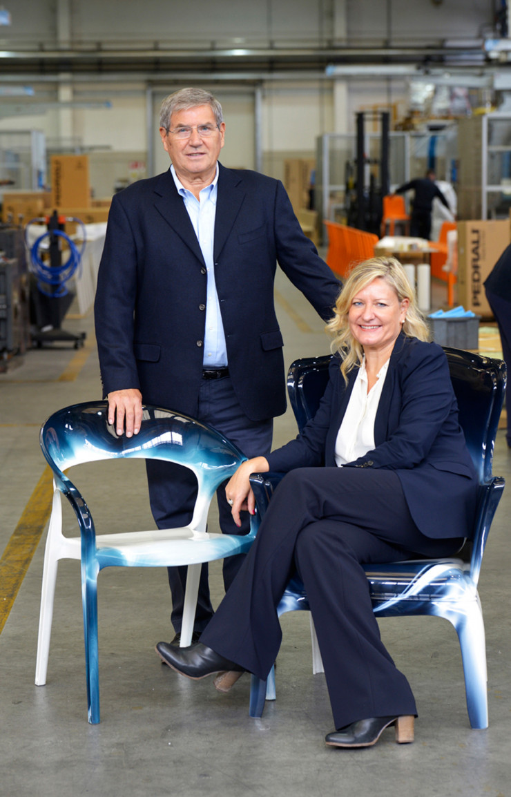 Mario Pedrali, le fondateur, et sa fille Monica posent dans l’usine sur des chaises Gossip et Pasha de Claudio Dondoli et Marco Pocci. Leur mélange de couleurs, qui provient du changement de teinte entre deux séries, les rend invendables, elles sont donc vouées au recyclage.