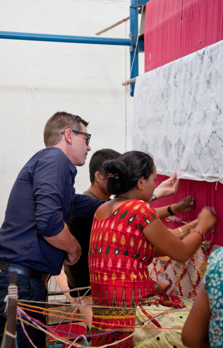 Des noueurs d’un atelier de Katmandou travaillent sur un modèle de la « Lost Weave Collection ». Un dessin suspendu guide leur travail.