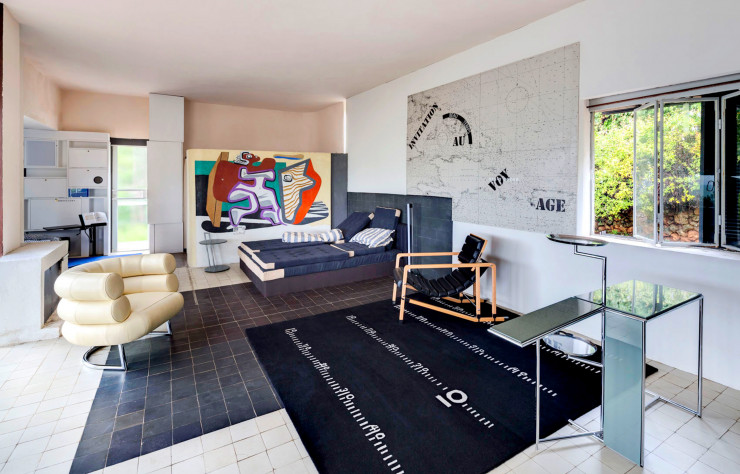 La pièce principale de la villa E-1027 avec le mobilier et le tapis conçus par Eileen Gray et la peinture murale de Le Corbusier.