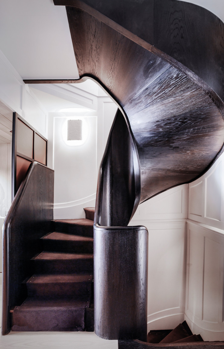 Le sublime escalier noir qui mène au premier étage a été entièrement conçu sur mesure pour s’adapter à cette maison ancienne aux murs de guingois.