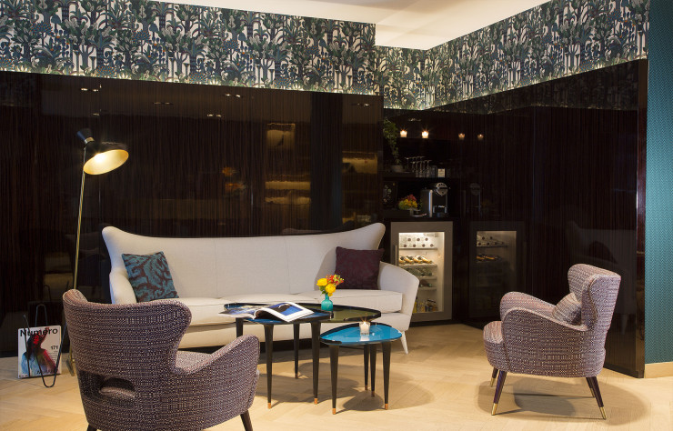 Le salon-bar de l’hôtel : un ensemble rétro relevé par une bande de tissu aux motifs végétaux signée Hermès.