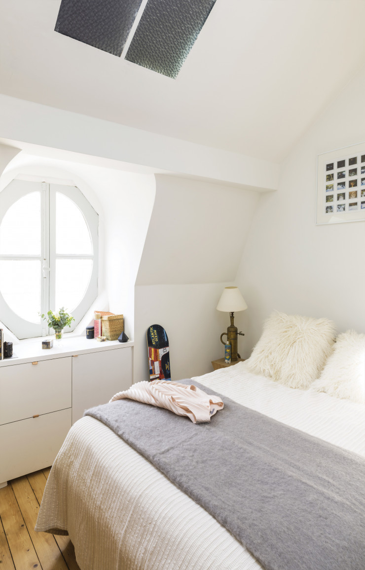 Pensée comme une retraite confortable, la chambre est un cocon tout en gris et blanc sur fond de parquet en pin clair.