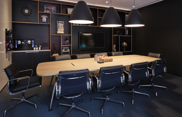 Plus studieuse, cette salle de réunion mise sur le noir, grâce notamment aux « Aluminium Chairs » de Charles et Ray Eames.