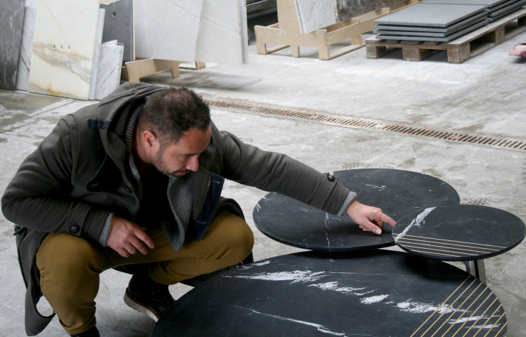 Le designer Alain Gilles au travail sur la finition de ses tables basses.