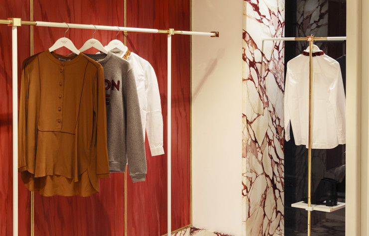 Chez Maison Père, boutique de prêt-à-porter féminin aménagée par le duo, le rouge domine. Les portants et les appliques en laiton sont bordés par l’un des motifs préférés du duo : le marbré.