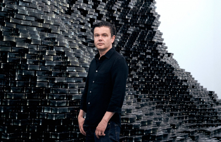Jean-Michel Othoniel devant The Big Wave, sa pièce en brique de verre indien noir et en métal.