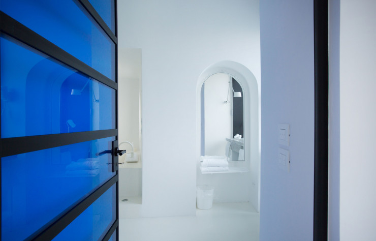 L’une des plus belles chambres de l’hôtel, avec ses panneaux de verre teinté de bleu et ses huisseries noires.