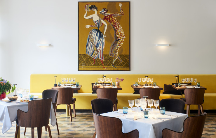 Avec son parquet en marqueterie et ses banquettes de velours safran, la salle du restaurant diffuse une atmosphère chaleureuse.