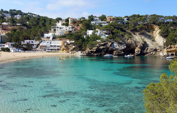 À l’ouest d’Ibiza, la petite crique de Cala Vadella abrite quelques bars et restaurants posés sur le sable blond, face aux eaux turquoise. Parmi eux, le Maya Beach Club Ibiza, qui s’étire entre la plage et la colline.