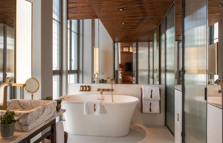 Les salles de bains et leur décoration sobre mêlent les matières nobles et brutes : le bois, la pierre et le verre. Leur superficie renforce l’aspect résidentiel de l’établissement.