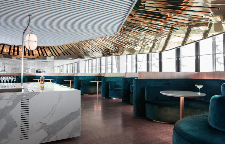 Dans le nouveau salon du hall L de l’aéroport Paris–CDG, le Balcon, signé Mathieu Lehanneur, est un bar circulaire qui s’enroule autour d’un cube de marbre central.