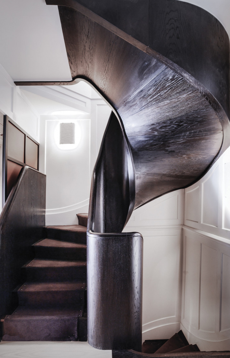 Le sublime escalier noir qui mène au premier étage a été entièrement conçu sur mesure pour s’adapter à la maison marque Connolly à Londres, aux murs de guingois.