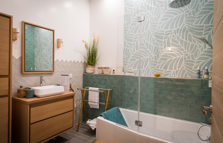De plus en plus apprécié après la vague des bleu profond, le vert s’affirme dans cette salle de bains à travers le carrelage et un revêtement mural spécialement adapté pour le protéger de l’humidité.