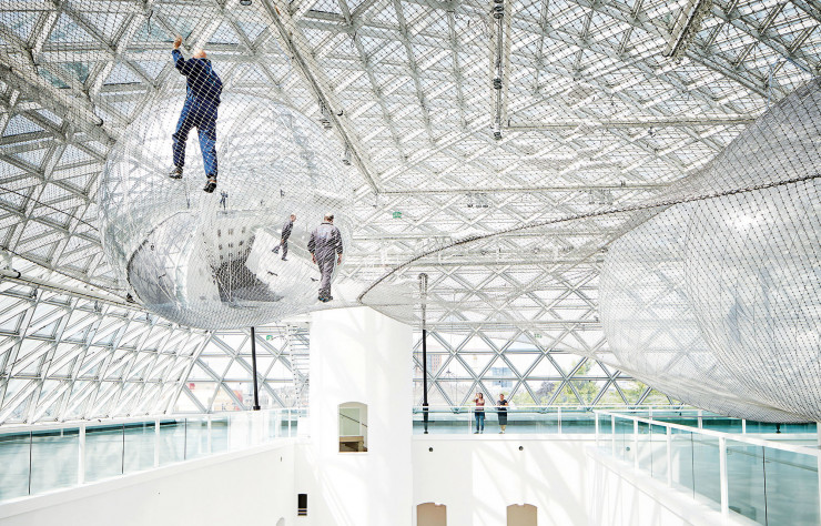 In Orbit (2013), l’installation vertigineuse de l’artiste Tomás Saraceno, suspendue à plus de 25 mètres au-dessus du sol, est l’une des principales attractions permanentes du K21, le département d’art contemporain du Kunstsammlung Nordrhein-Westfalen.