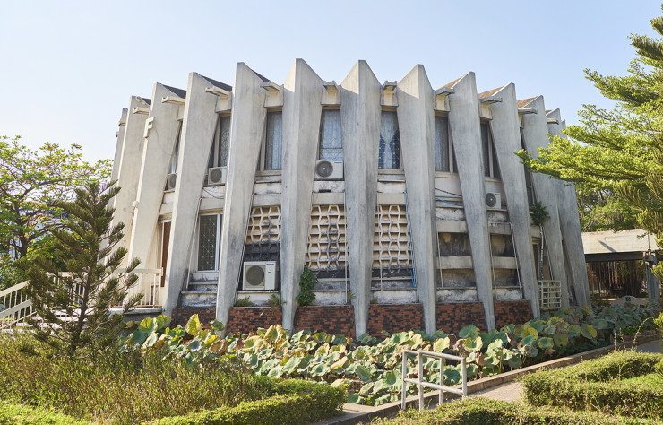 L’entrée de l’Institut des langues étrangères, à Phnom Penh, est marquée, à l’ouest du hall central, par cette bibliothèque circulaire posée sur ses pattes de béton telle une araignée géante. Ce complexe, imaginé par Norodom Sihanouk en 1965, continue de remplir son programme initial : ouvrir le Cambodge sur le monde.