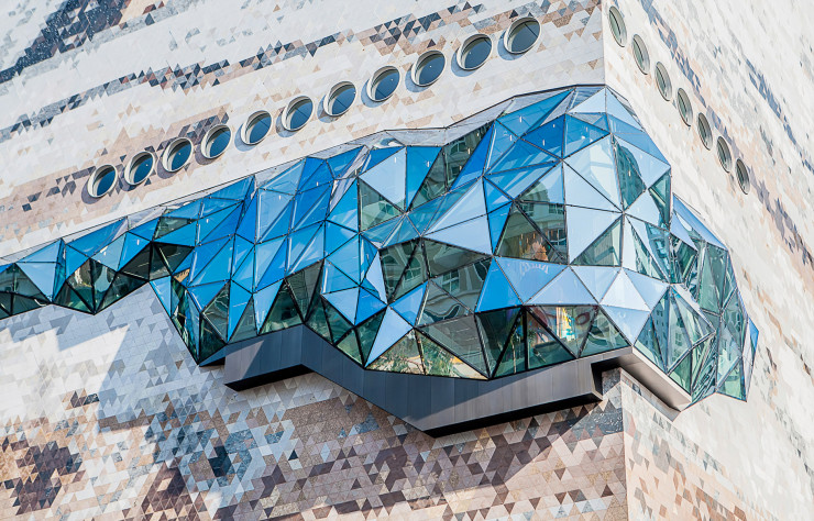 Avec sa façade en pierre et ses excroissances en verre, le bâtiment d’OMA tranche radicalement avec les architectures banales qui composent la ville de Gwanggyo.