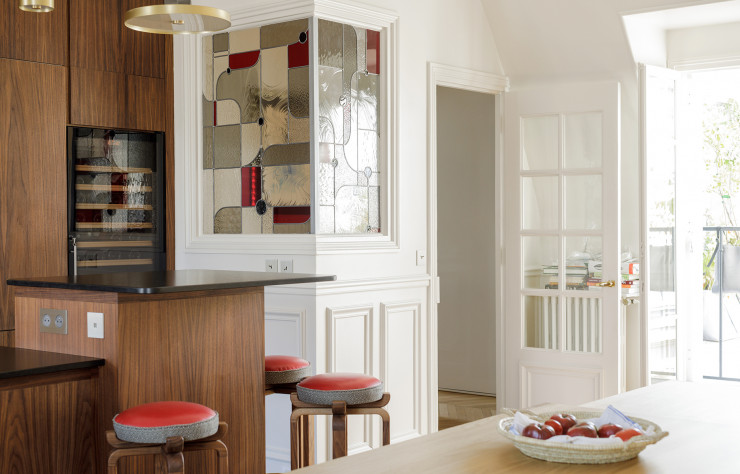 Dans cet appartement doté d’une nouvelle cuisine, un vitrail résonne avec les premières versions des tabourets Serti.
