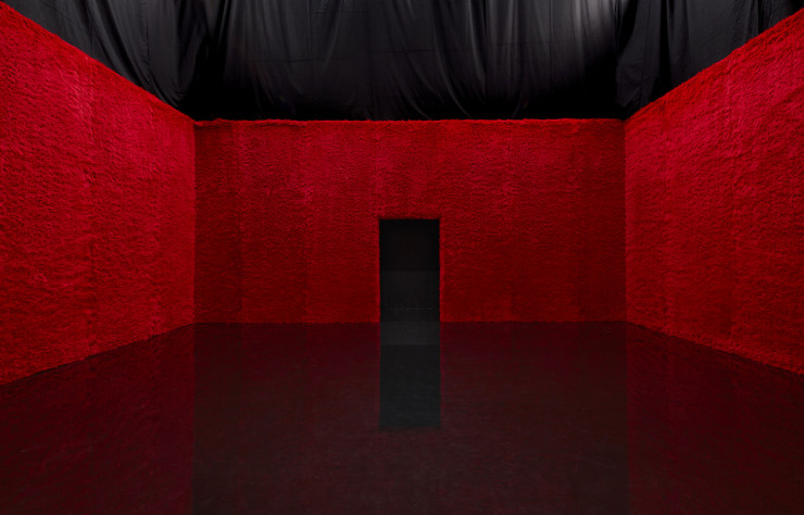 Fourrure et sol en résine noire dans la première salle du défilé Prada conçu par Rem Koolhaas.