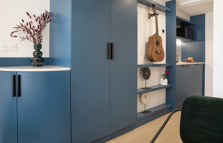 Du mobilier sur mesure s’adapte à la forme des pièces en I (pour deux personnes) afin d’accentuer la transition d’espaces. Ici, la guitare marque l’identité de l’appartement du musicien.