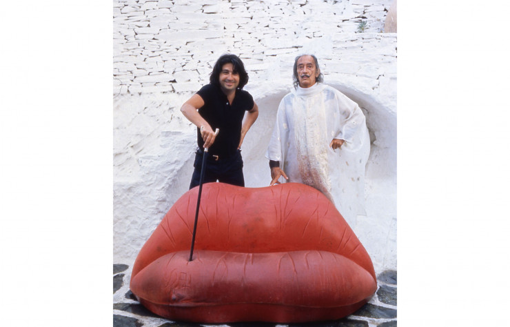 Oscar Tusquests, un des cofondateurs de BD Barcelona avec Dali devant le canapé Mae West dit Bocca.