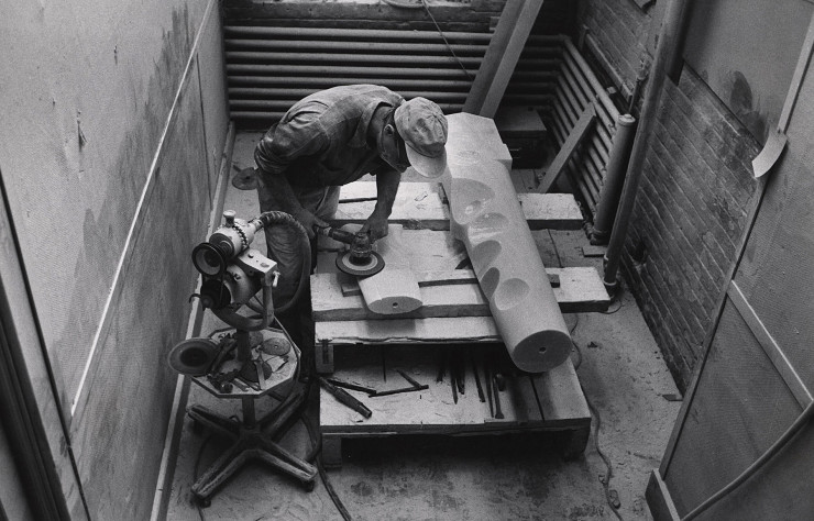 Isamu Noguchi en train de travailler sur sa « Figure Portion of Composition for Arrivals Building » en marbre grec pour l’aéroport d’Idlewild en 1958. Archives du Noguchi Museum.